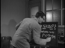 Clark writes on the chalkboard and figures out the code