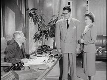 Clark and Lois talk to Perry White in his office